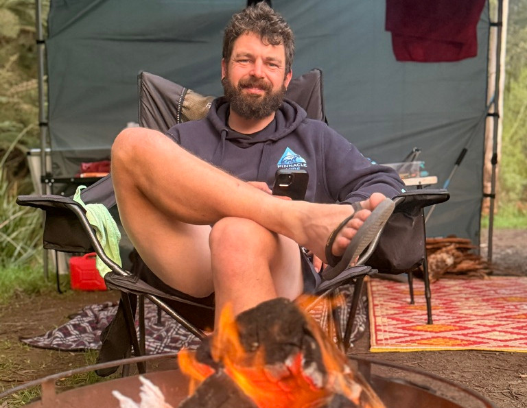 James in front of a fire when camping with family