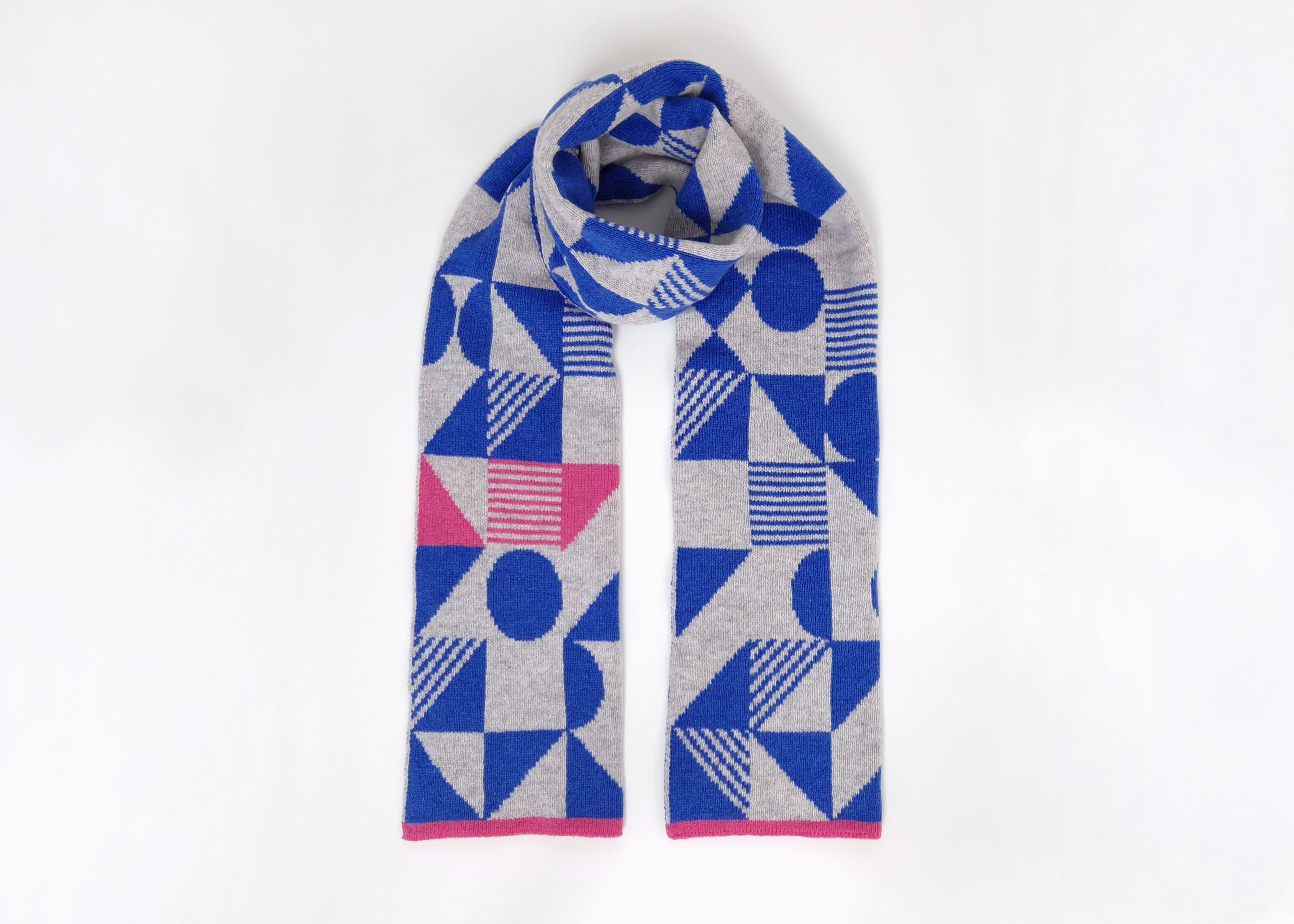 Geometric patterned reversible scarf in blue and grey with pink highlights. Knitted in 100% Lambswool