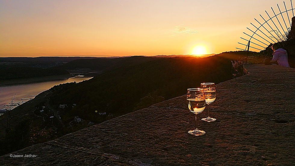Two glasses of champagne with a golden sunset behind the Mountain Ranges of Kellerwald and Lake Edersee in the background
