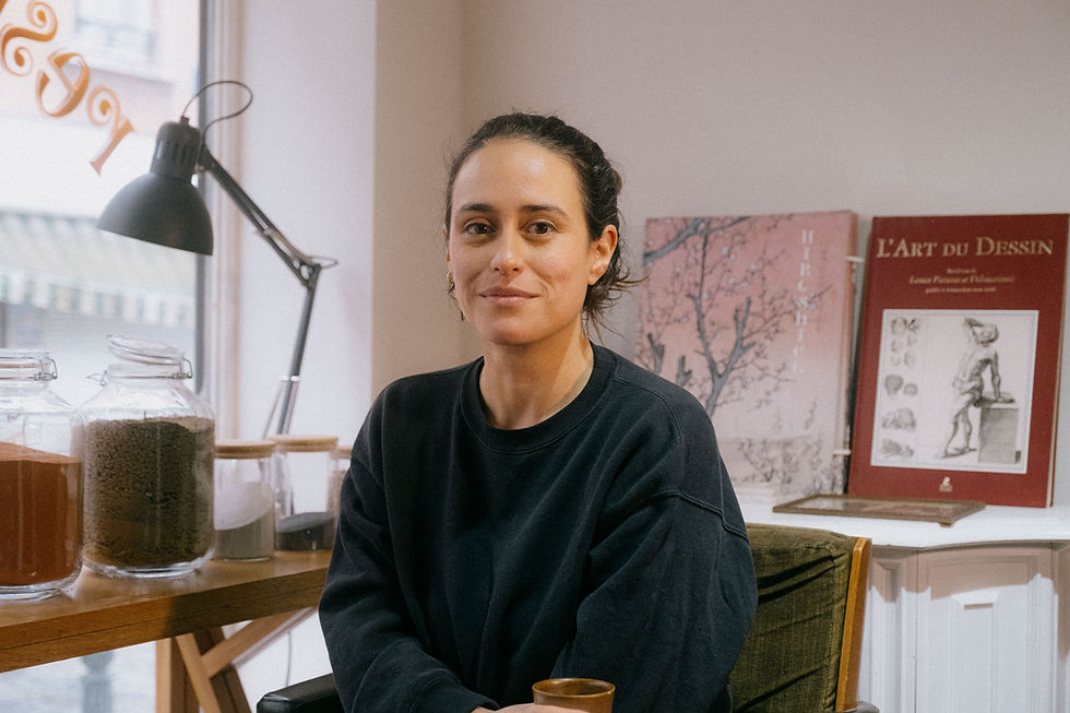 Woman in studio with pigments and the book The Art of Drawing