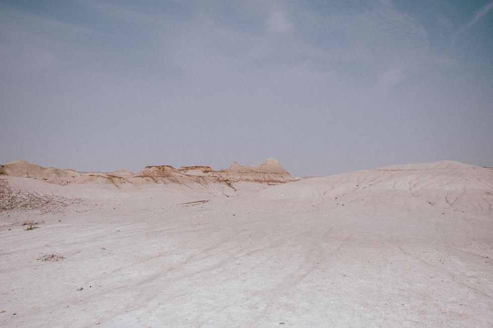A desert landscape of white sand hills under a clear sky
