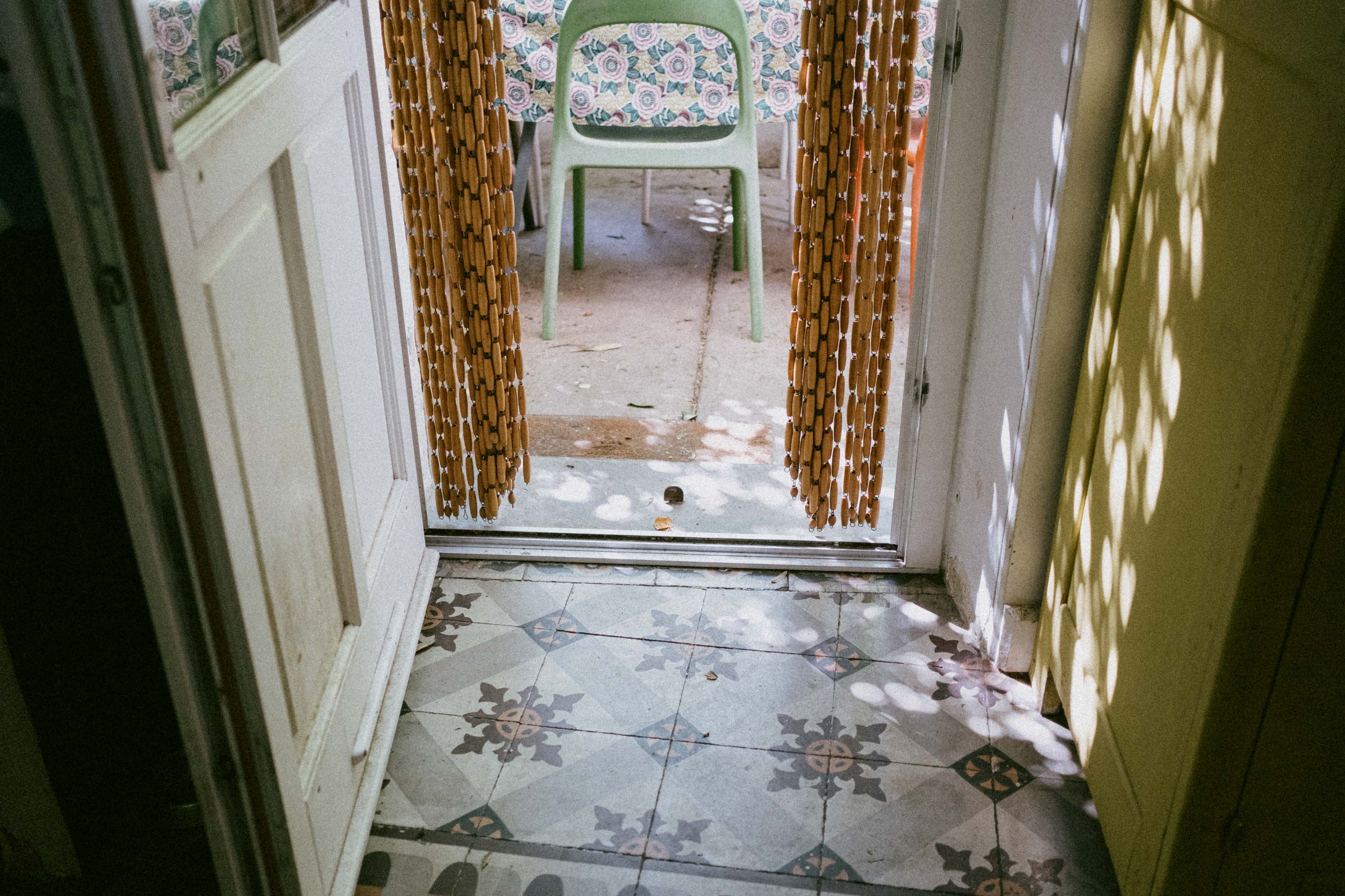 View from inside towards a terrace with old tiles.