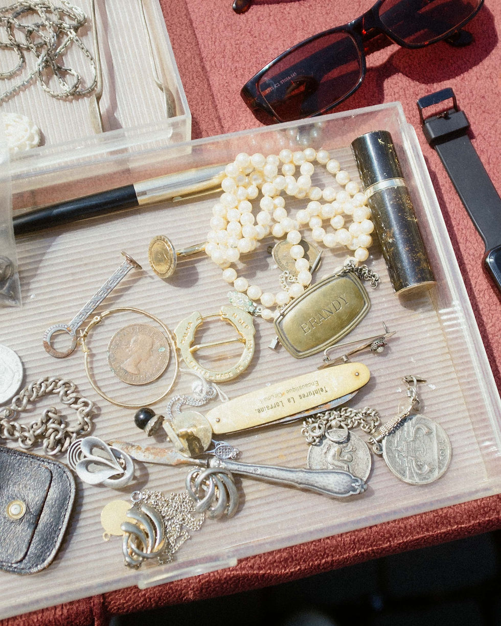 A transparent tray filled with antique jewelry and beads