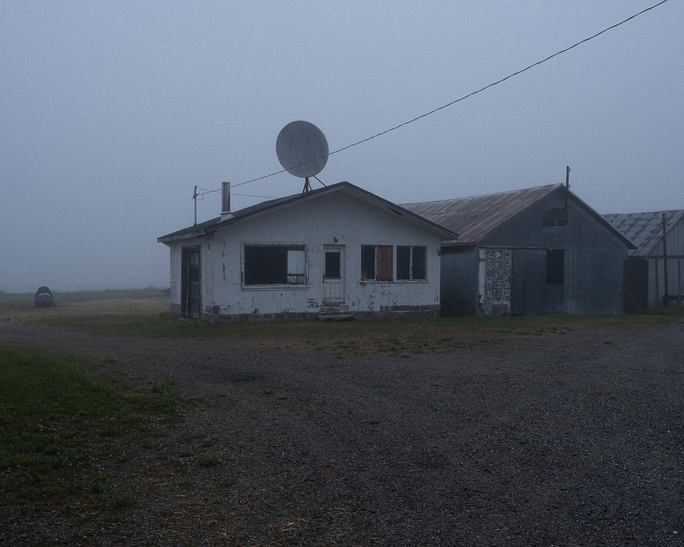 Abandoned white house with a satellite dish in the fog.