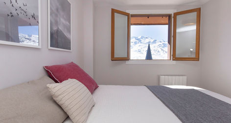 Dormitorio principal con vistas a la estación de Formigal desde el balcón del apartamento turístico Ventana de Formigal by Bevalle en Formigal