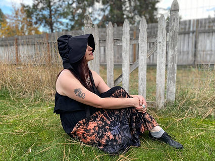 Artist Kimberly Helgeson Sams in front of a rustic gate.