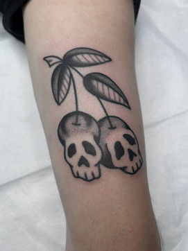 Skull Cherries American Traditional Tattoo Trad Tattoo Black and Grey by Erik Jeffrey. Death Proof Tattoo and Barber. Whistler, BC. Pemberton, Squamish, Vancouver Canada. Tattoo Studio. Tattoo Shop. Barber Shop. Tattoo Artist. Professional Services.