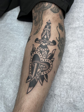 Heart RoseDagger American Traditional Tattoo Trad Tattoo Black and Grey by Erik Jeffrey. Death Proof Tattoo and Barber. Whistler, BC. Pemberton, Squamish, Vancouver Canada. Tattoo Studio. Tattoo Shop. Barber Shop. Tattoo Artist. Professional Services.