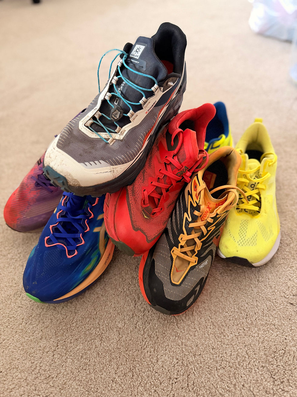 collection of running shoes piled up on the floor