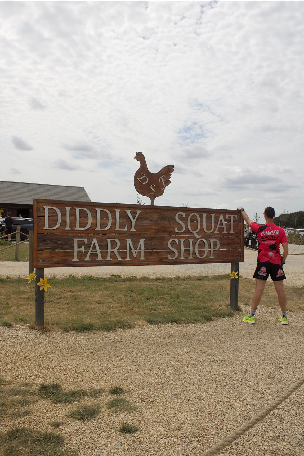 Andy Hood runner standing by Diddle Squat Farm Shop sign