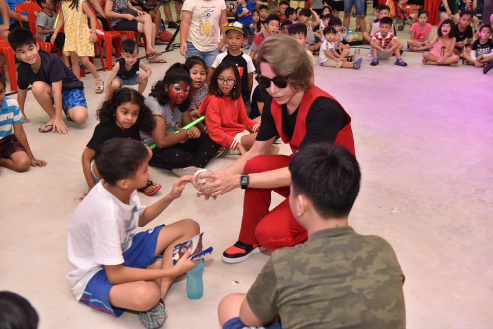 Eye-level view of a vibrant street performance featuring a juggler at Clarke Quay