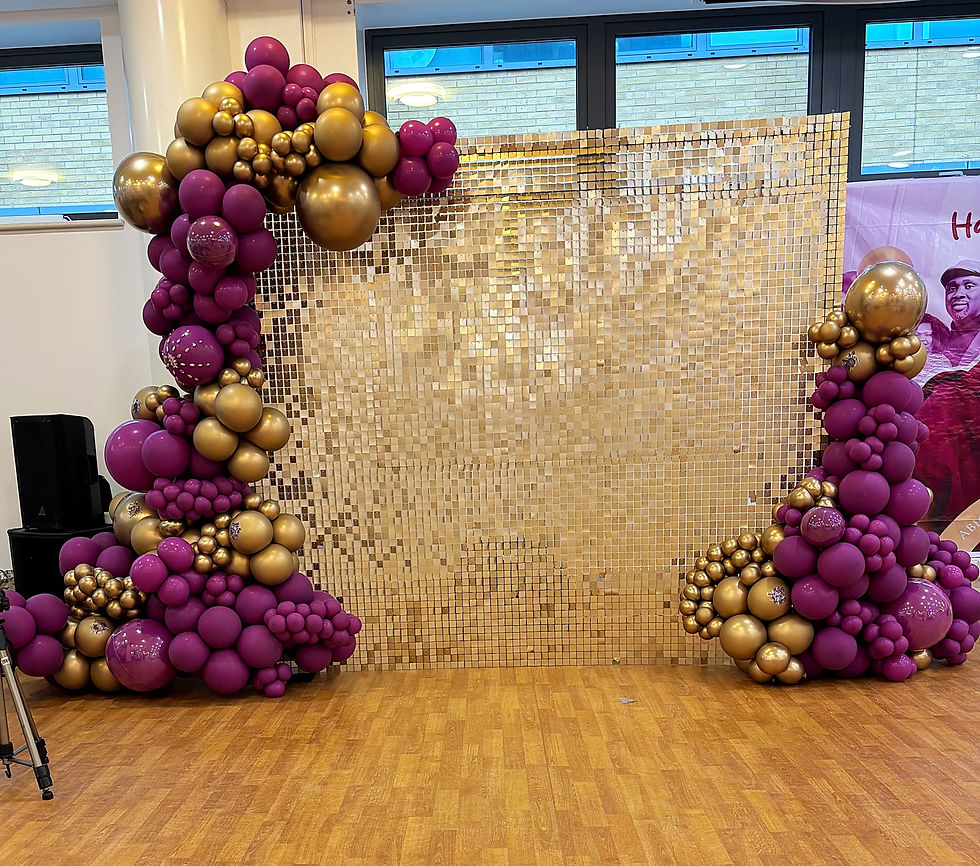 Luxury event photo backdrop featuring a shimmering gold sequin wall flanked by organic purple and chrome gold balloon garland