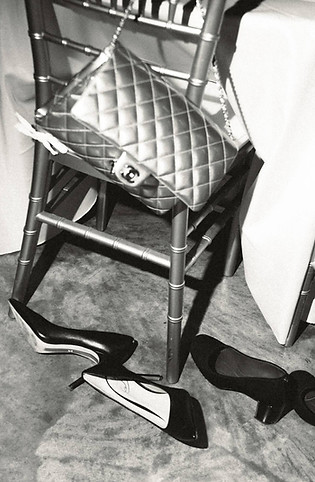 A black and white flash photo of a Chanel bag and heels at a wedding reception in Nashville, TN. 