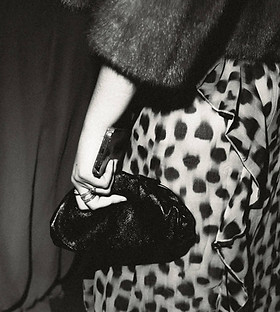 Black and white editorial flash image of a wedding guest's outfit.