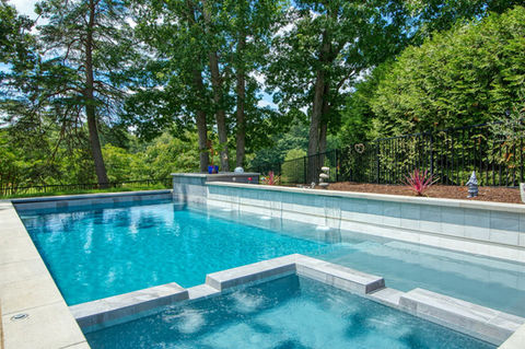 a fiberglass pool with a built in jacuzzi section