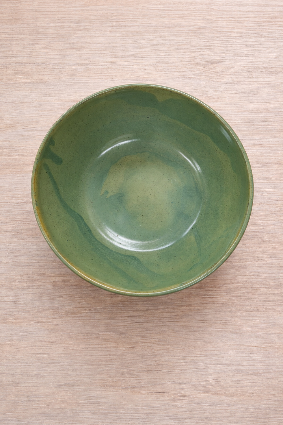 top view of Pandanus large serving bowl with tones of green, yellow on a wooden table