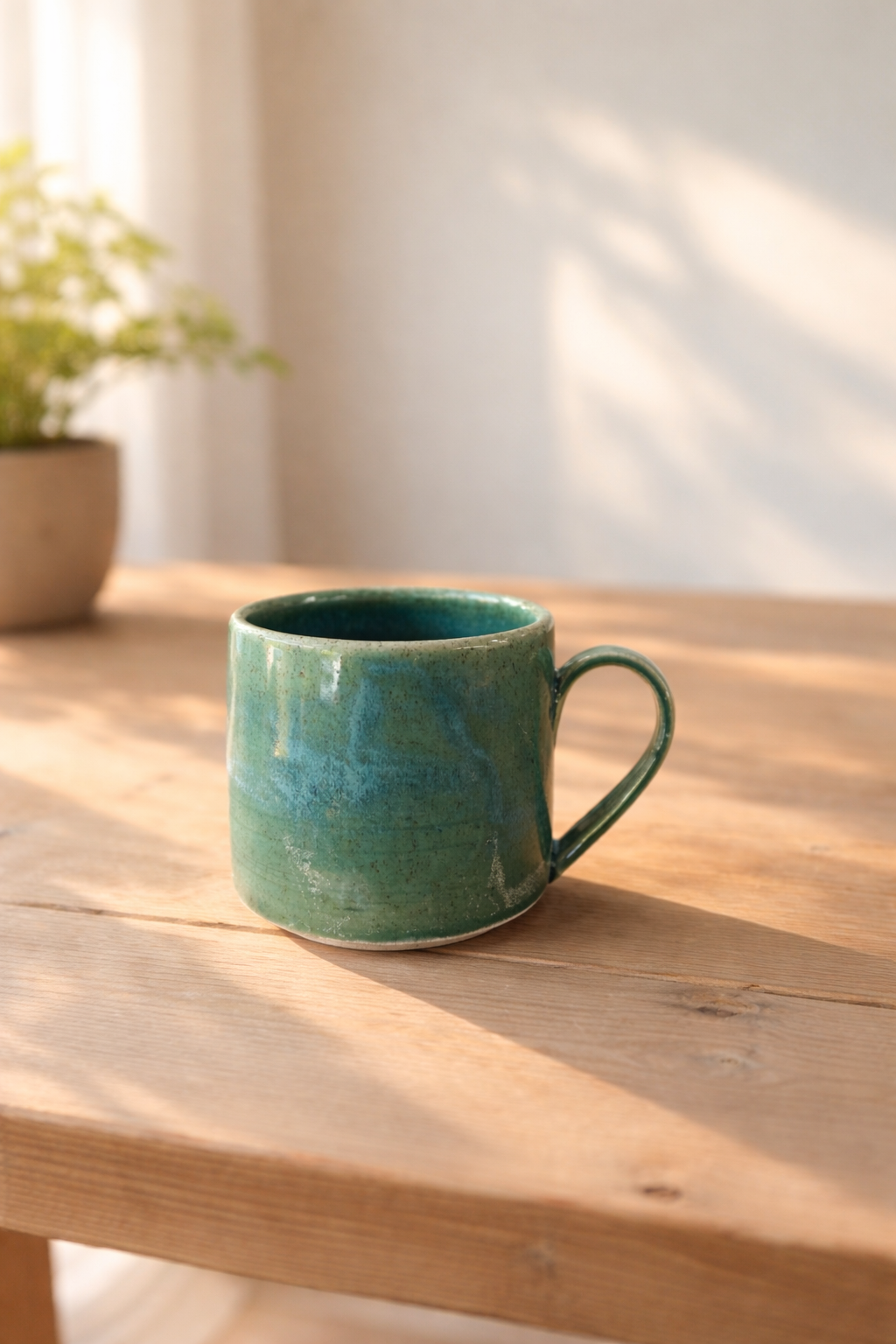 Handmade kuitpo mug in deep forest greens with rounded comfortable handle