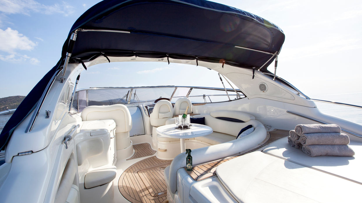 Luxury motorboat interior: comfortable seating, sunshade, and towels
