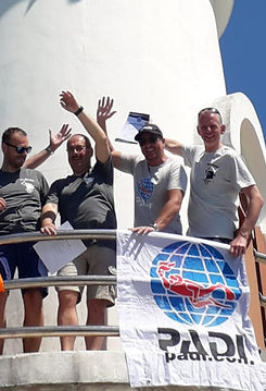 Groupe de professionnels de la plongée tenant un drapeau PADI