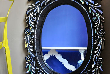 A Thai, carved wood wall mirror decorated with intricate mirror mosaics.