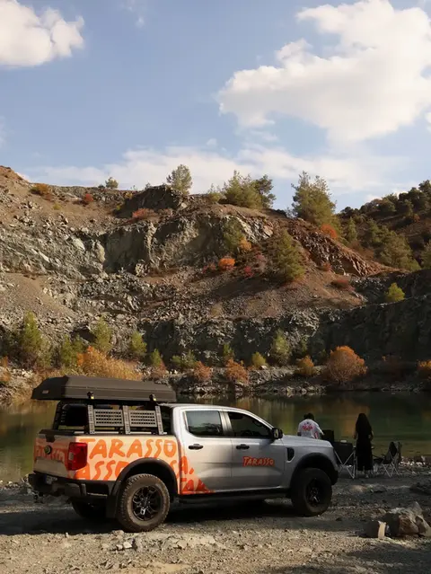 Ford Ranger Tarasso Camper Truck, is parked next to the lake