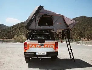 Ford Ranger Camper truck with open rooftop tent back side.