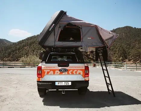 Ford Ranger Camper truck with open rooftop tent back side, and mountains in the background