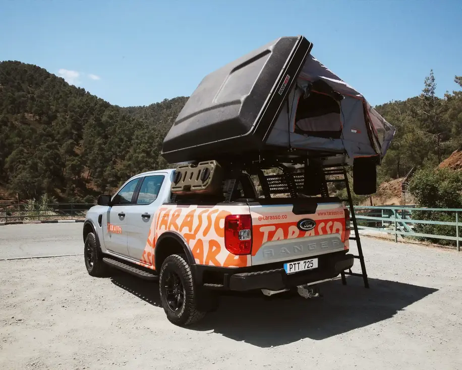 Ford Ranger Camper truck with open rooftop tent back side, and mountains in the background