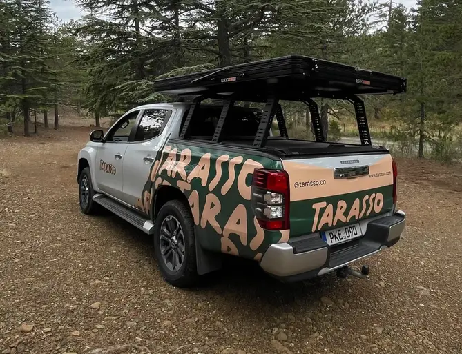 Mitsubishi L200 Tarasso Camper Truck, with open rooftop tent in the forest