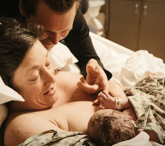 A birth doula client at Northside Fulton Hospital is holding her baby after being supported by her doula during her birth.