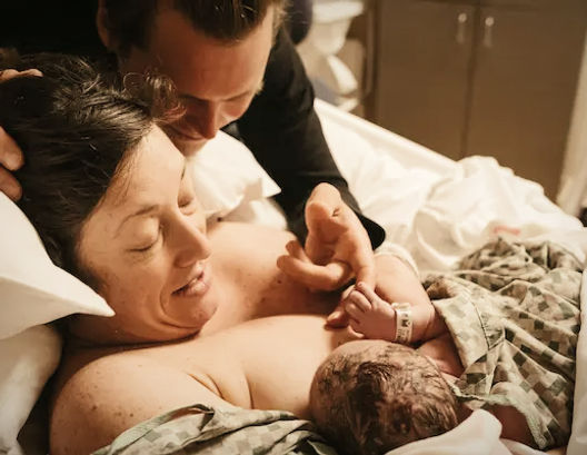 A birth doula client at Northside Fulton Hospital is holding her baby after being supported by her doula during her birth.
