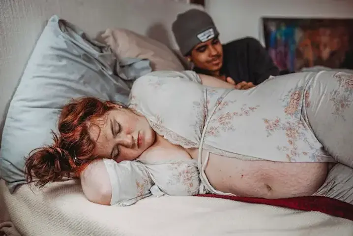 woman laboring in bed at her home in atlanta being supported by her doula