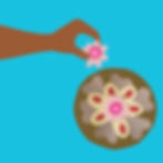 Hand placing flower on decorated cake