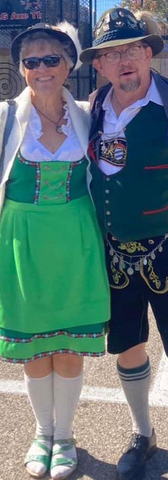 woman on left in green German outfit. man on right in traditional German lederhosen