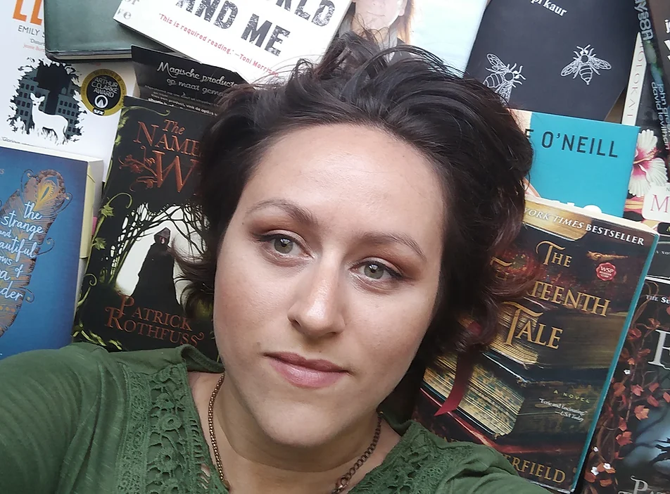 Close up of Cat Rector lying on top of books for an author photo