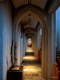 Photo of stained glass window down long narrow hallway
