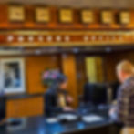 The Queen Mary's Pursers Office desk with old wood paneling and clocks with the time of Long Beach, New York Paris and other locations.