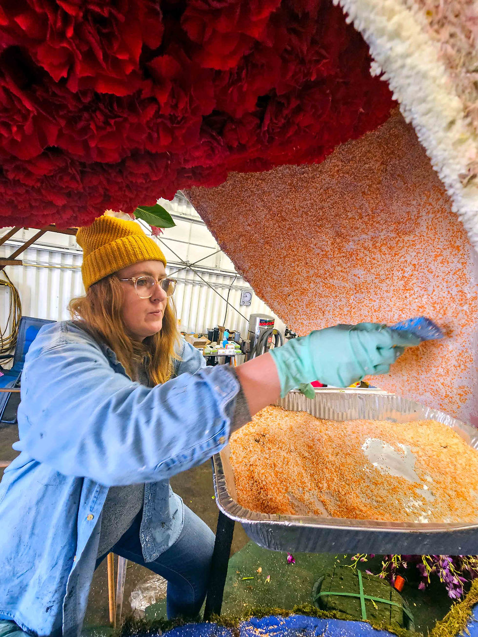 Photo of woman gluing pink substance onto parade float flamingo