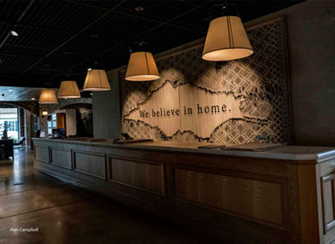 Photo behind large service counter inside store with words, We Believe in Home, posted on wall behind