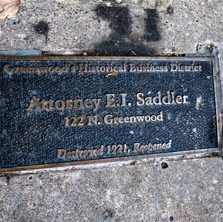 Photo of plaque in sidewalk listing Attorney E. I Saddler. One of many similar plaques noting where businesses were located at time of 1921 riot