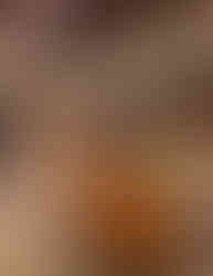 Photo of two cocktails glasses with bar and bartender in background