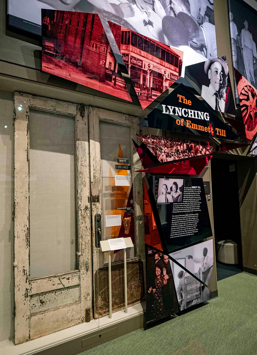 Photo of Bryant Grocery doors on display at the museum with photo of the story above them and sign that reads, The Lynching of Emmett Smith.