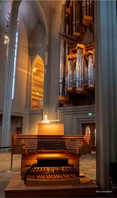 Photo of pipe organ behind large organ which plays it