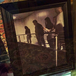 Photo of people looking over a railing with a supposedly mysterious ghost behind man in white shirt