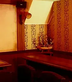 Interior of Grand Pirates maid cafe in Akihabara, featuring warm lighting, wooden seating, and pirate-themed decorations.