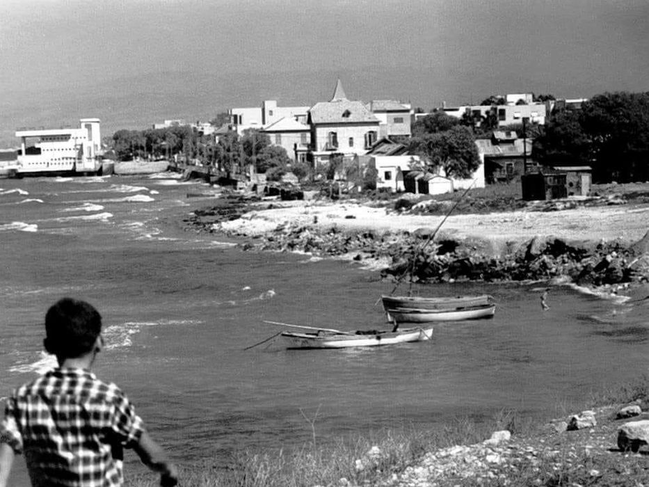 Black and white photo: seaside houses, boats, and child