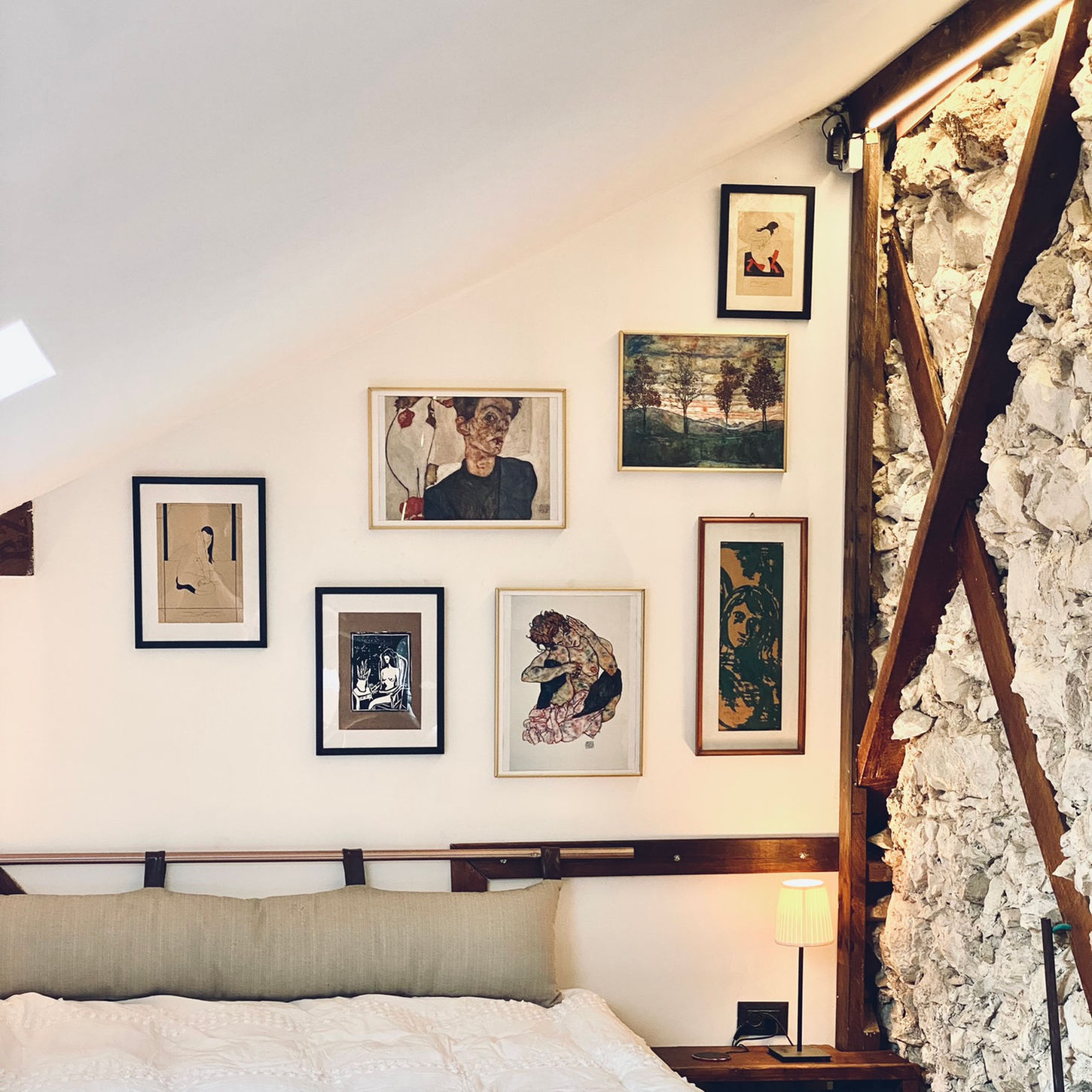 Gallery wall above bed in cozy loft room