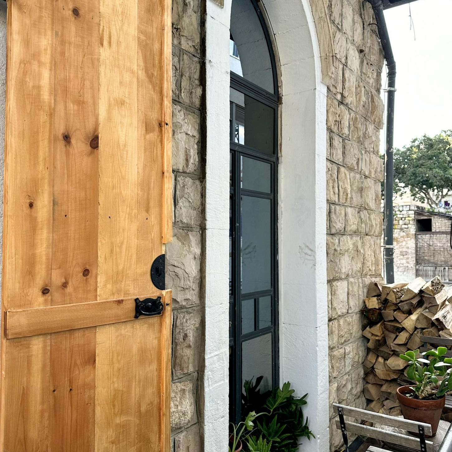 Stone building entrance, wooden door, plants