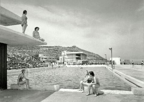 Black and white photo: people at a 1960s pool