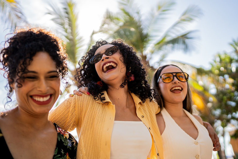 Three women with arms wrapped around each other and smiling.